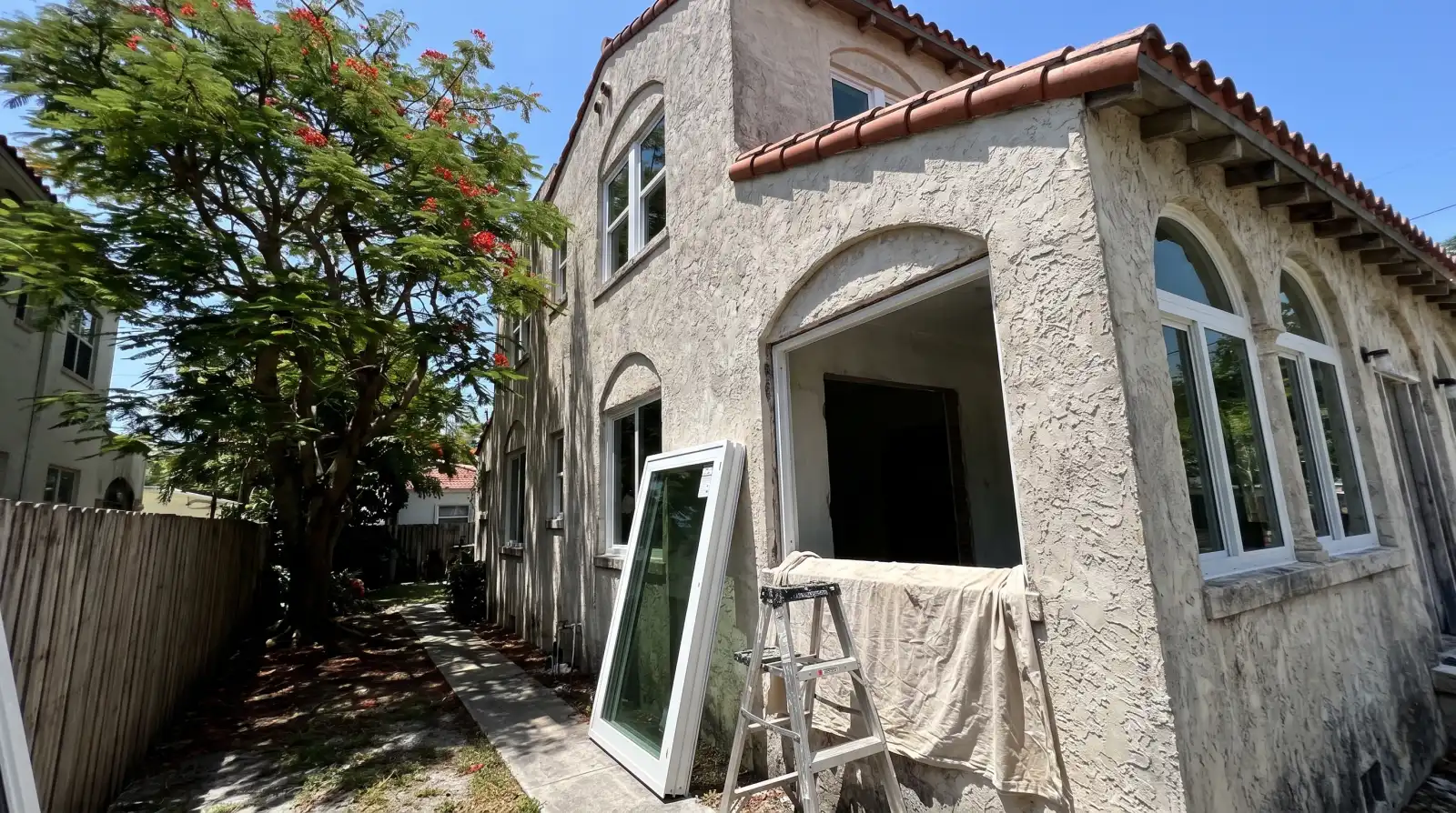 Impact windows being installed on an older stucco home in Miami, FL